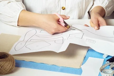 Handcrafted do it yourself tutorial. Cropped female tailor hands cutting out Stock Photos