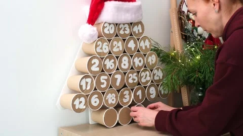 Handcrafted eco-friendly Advent calendar scene showcasing a hand reaching into a Stock Footage 316753689