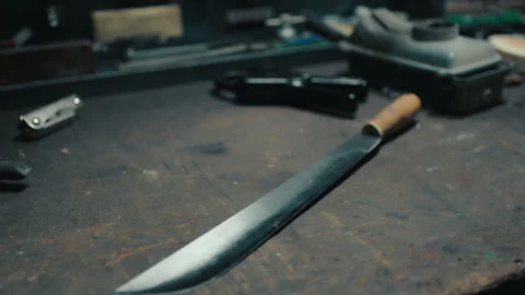 Handcrafted machete blade resting on workshop workbench Stock Footage 335493393