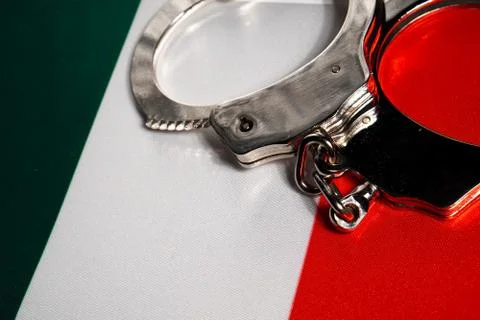 Handcuff on the flag of Italy. Close-up, copy space Stock Photos