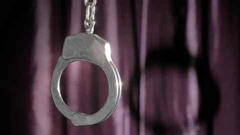 The handcuff sways against a backdrop of glare and strobe light. Stock Footage 167253645
