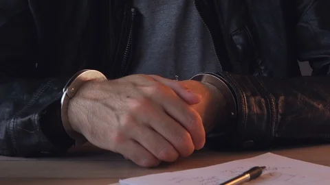 Handcuffed criminal giving statement during police interrogation Stock-Footage 98266547