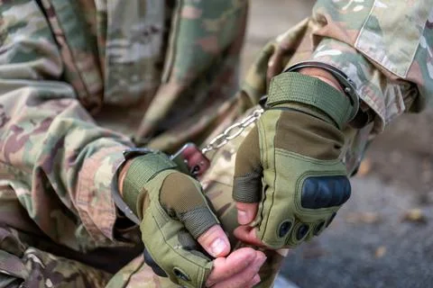 Handcuffed hands of detained serviceman in close up 스톡 사진