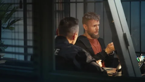 Handcuffed man giving a statement to a police officer, criminal confession Stock Footage 340031602