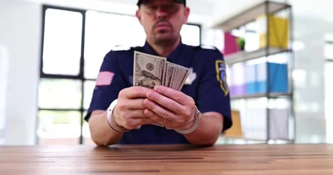 Handcuffed policeman holds bunch of dollars to avoid punishment Stock Footage 252205871