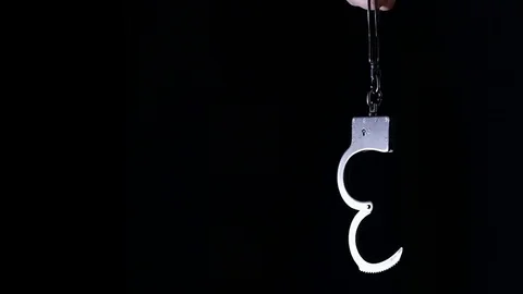 Handcuffs on a black background in slow motion Stock Footage 123052876