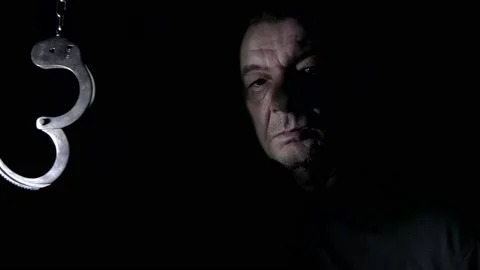 The handcuffs cast a shadow on the face of a potential prisoner. Stock Footage 166940687