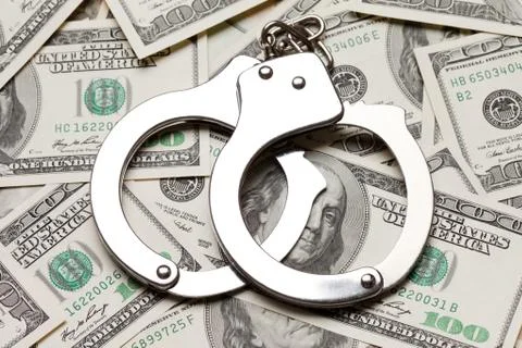 Handcuffs on dollar currency Stock Photos