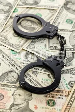 Handcuffs on dollars Stock Photos