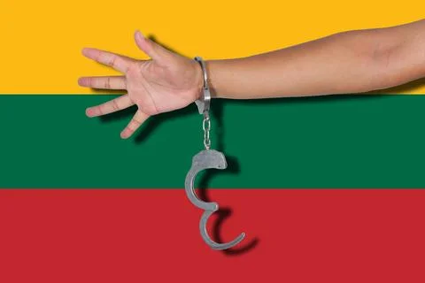 Handcuffs with hand on Lithuania flag Stock Photos