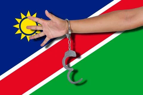 Handcuffs with hand on Namibia flag Stock Photos