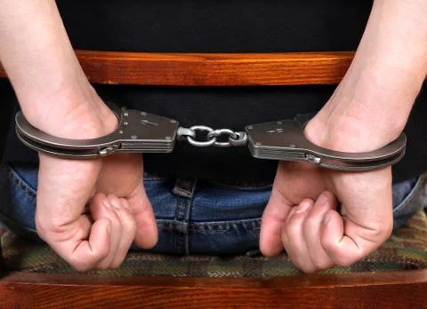 Handcuffs on Hands closeup Foto stock