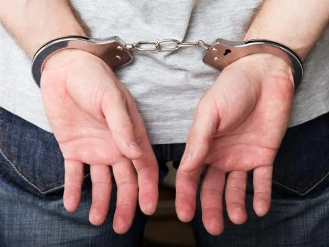 Handcuffs on hands Stock Photos