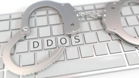 Handcuffs on keyboard with DDOS or Distributed Denial of Service text. Computer Ilustração Stock