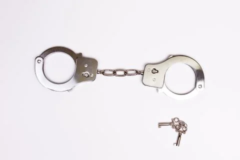 Handcuffs with keys isolated Stock Photos