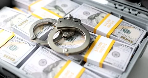 Handcuffs lie on stack of dollars in a suitcase, close-up. Stock Footage 236403986
