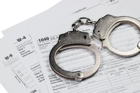 Handcuffs over Tax forms, concepts: Tax fraud or Slave to the Taxes Stock Photos