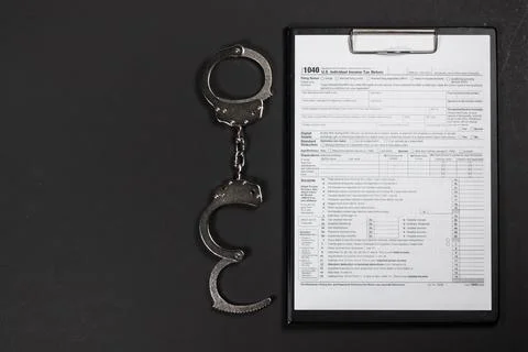 Handcuffs over Tax forms, concepts: Tax fraud or Slave to the Taxes Stock Photos
