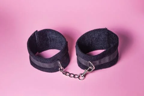 Handcuffs on a pink background. Stock Photos