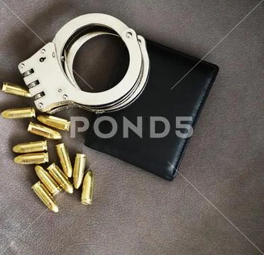 Handcuffs, pistol bullets and ID holder for cops, special forces and defense Stock Photos