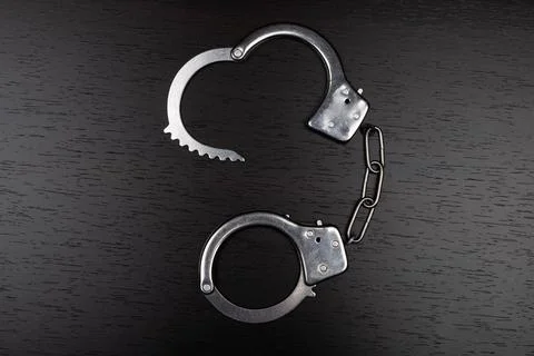 Handcuffs on table, concept of arrest for violation Stock Photos
