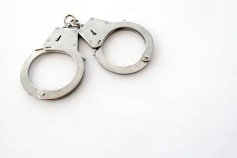 Handcuffs on a white background in the upper left corner of the frame. Copy s Stock Photos