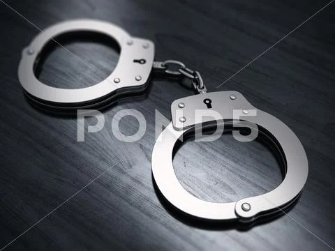 Handcuffs on wooden table Stock Photos
