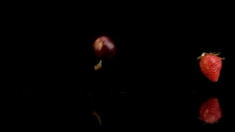  A handful of bright red cherries dropped onto black surface Stock-Footage 111945491