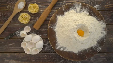 Handful of flour with egg yolk on a dark wooden background Stock Footage 62068572