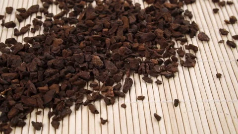 A handful of instant dried chicory root falls in slow motion onto a bamboo tr Stock Footage 152143156