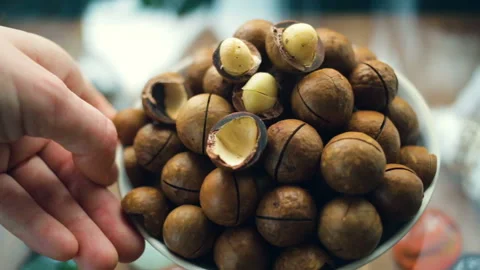 A handful of macadamia in a plate close-up. Hand rotates around its axis plate. Stock Footage 104934734