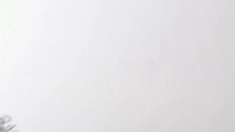Handful of paperclips thrown onto a white surface from off screen. Stock Footage 117349934
