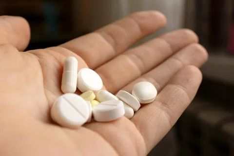 A handful of pills in hands Stock Photos