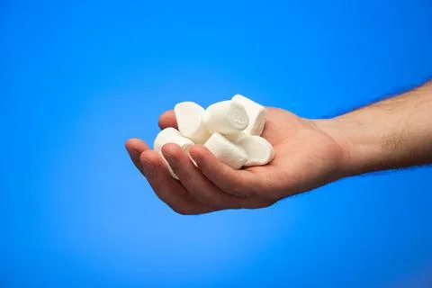 Handful of raw white marshmallows held in hand by Caucasian male close up stu Fotos de archivo