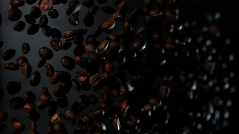 A handful of roasted coffee beans fly into the camera in slow motion Video stock 109154678