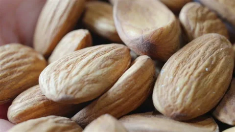 A handful of untreated almonds extremely close-up, contains people, shallow dept Stock Footage 112025891