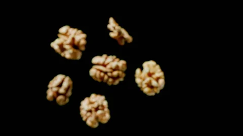 Handful of walnuts flies up and falls on a black background. Top view Stock Footage 149157615
