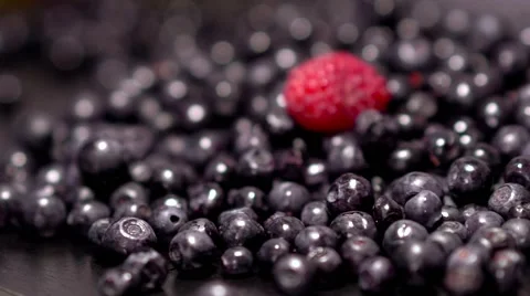 A handfull of raspberry falls on bluberries Stock Footage 65776109