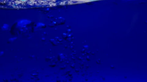 Handgun falling slow motion in water with bubbles on in blue water Stock Footage 219521213