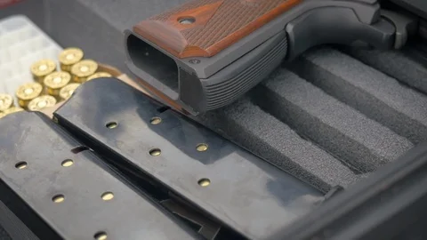 Handgun with Loaded Clips and Ammo Representing Gun Control in Slow Motion Stock Footage 87847820