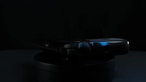 Handgun rotates on a platform black background 스톡 동영상 127949136
