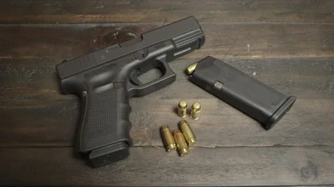 Handgun on table with ammo Stock Footage 143978068
