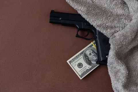 Handgun on the US dollars stack - - criminal money concept Stock Photos