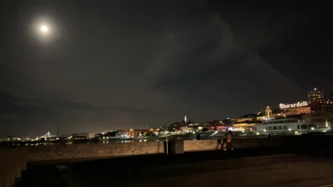 Handheld 4K Shot Full Moon People Walking Bikers Full Moon lights Stock Footage 144581244