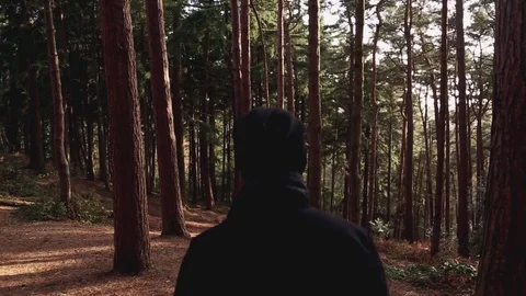 Handheld and tracking shot of man in jacket walking in forest with his bag 스톡 동영상 114841955