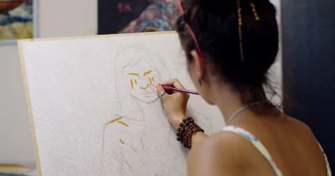Handheld back view of young artist working on portrait picture in home studio Stock Footage 165641462