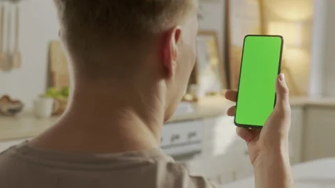 Handheld Camera: Back View of Blond Man Holding Chroma Key Green Screen Stock Footage 205572397