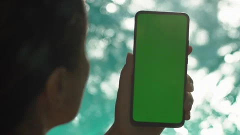 Handheld Camera: back view of brunette holding chroma key green screen Video stock 137864711