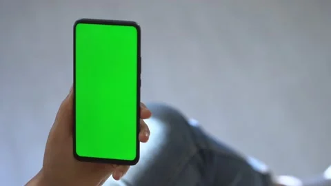 Handheld Camera: Back view of brunette holding chroma key green screen Stock Footage 141098256