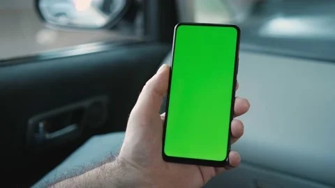 Handheld Camera: Back View of Man in car Holding Chroma Key Green Screen Stock Footage 163349375
